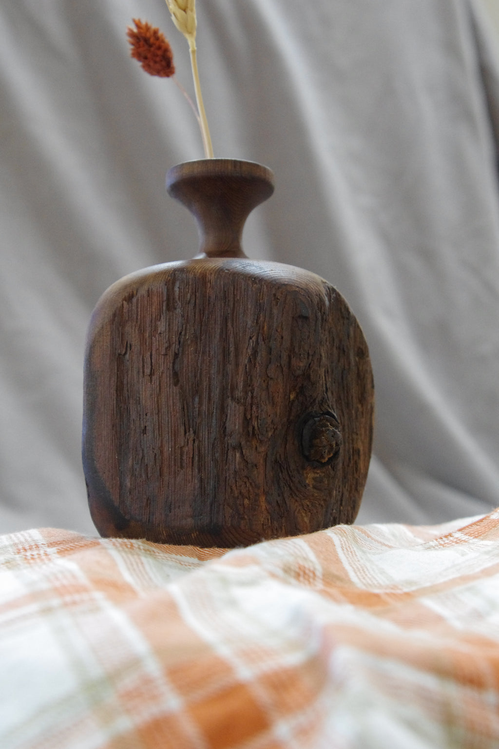 wooden twig vase on plaid cloth this vase is the one with a notch