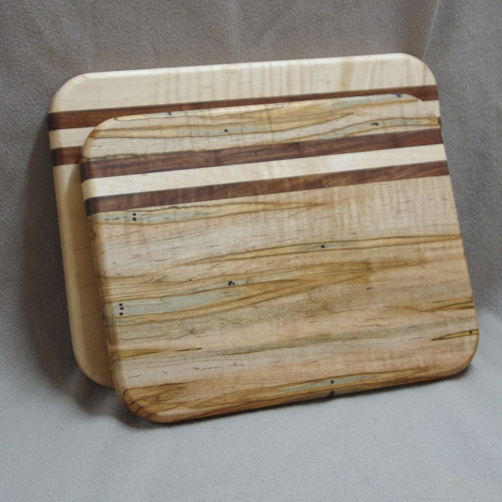Two maple cutting boards the one in front being ambrosia maple with walnut accents. The one in back being maple with walnut accents. 