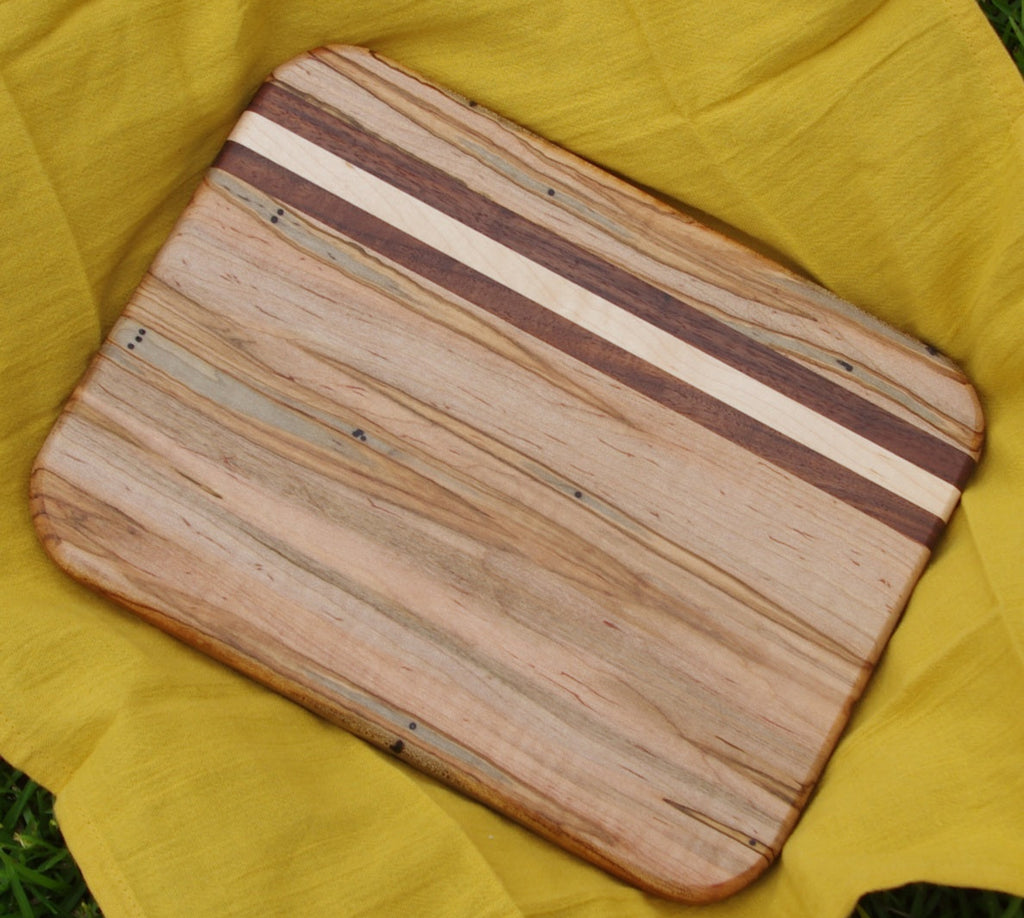 Ambrosia maple cutting board with maple and walnut accents, featuring a unique blend of light and dark wood tones. The smooth, polished surface and durable construction make it ideal for chopping, slicing, and serving, while adding a touch of natural elegance to your kitchen.