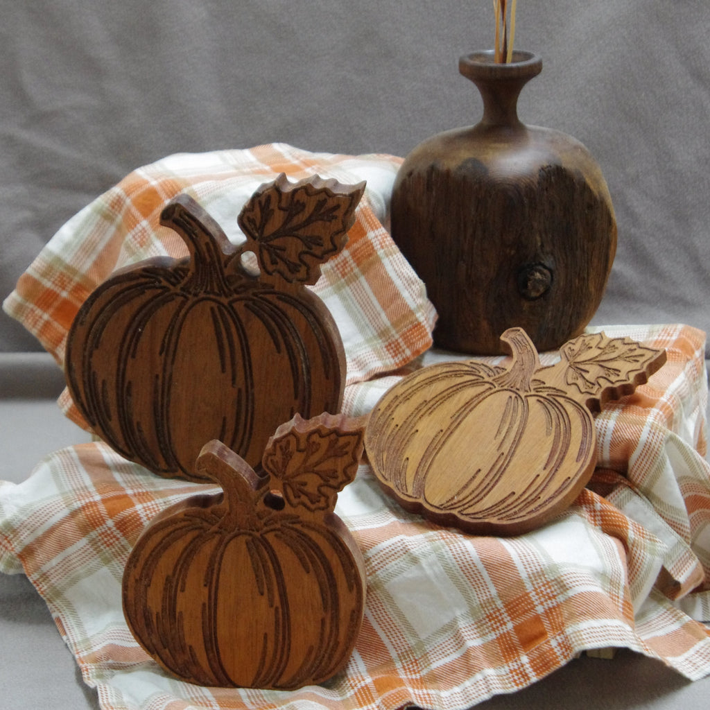 Decorative pumpkins with a vase on a plaid cloth with a gray background