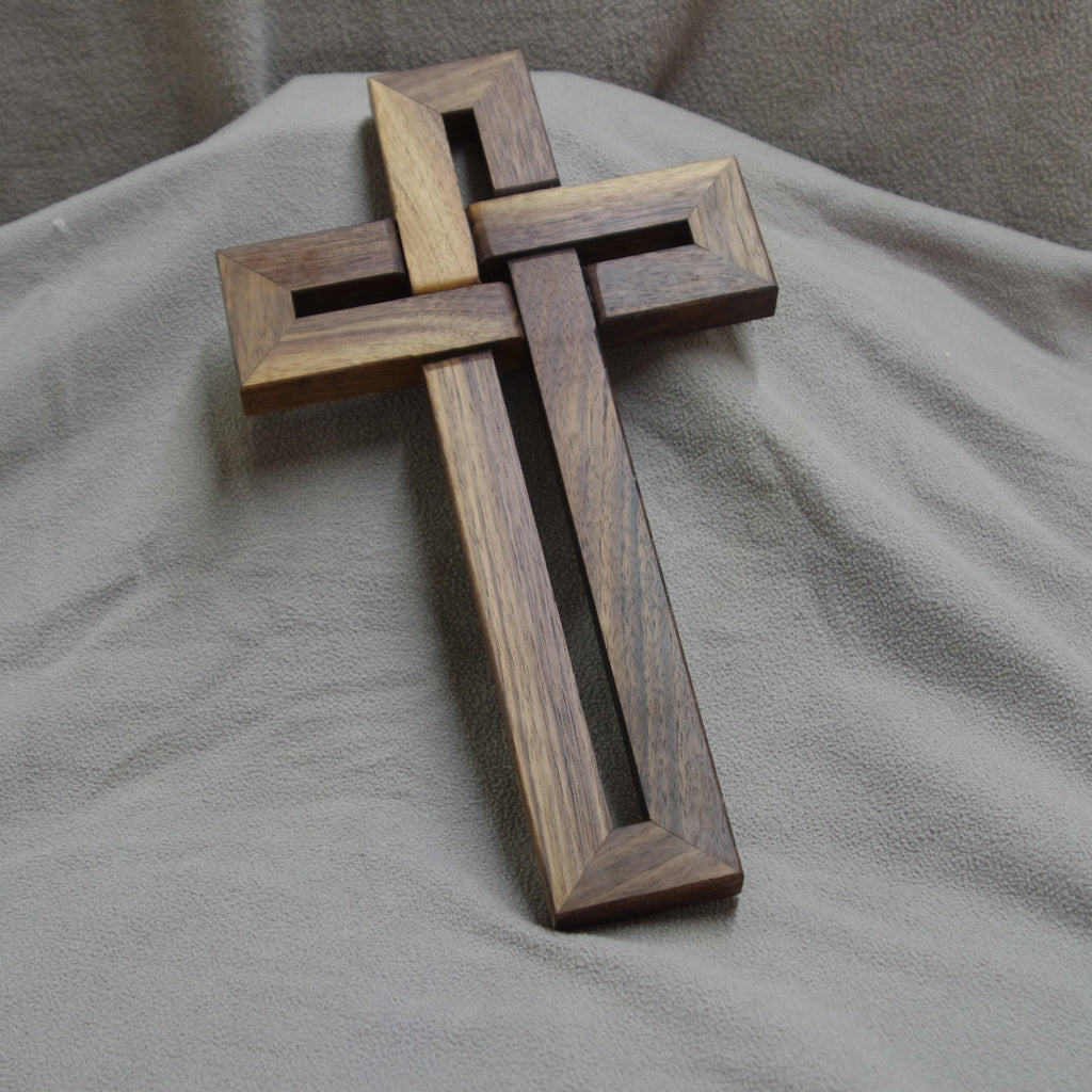 Wooden cross on a gray fabric background