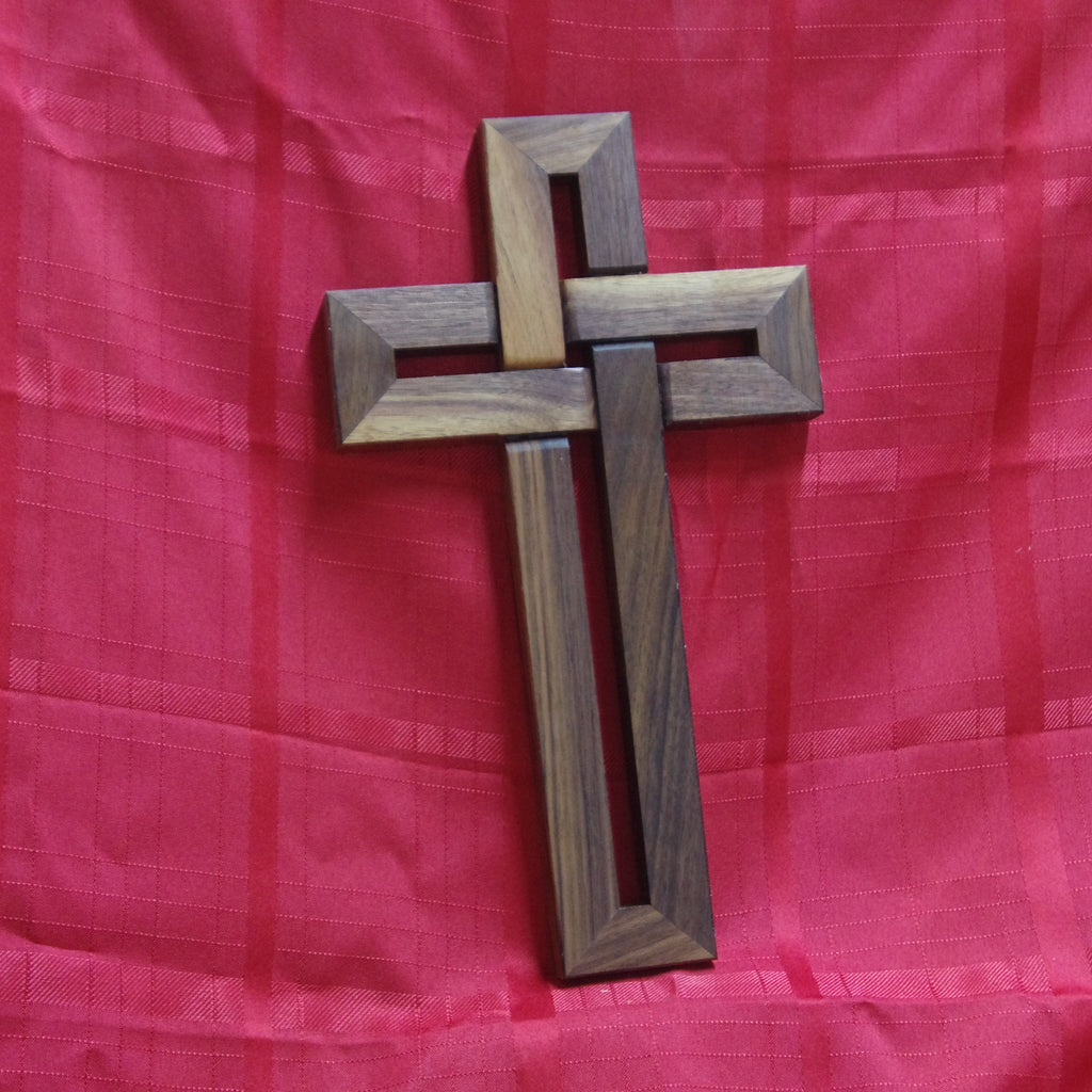 Wooden cross on a red fabric background