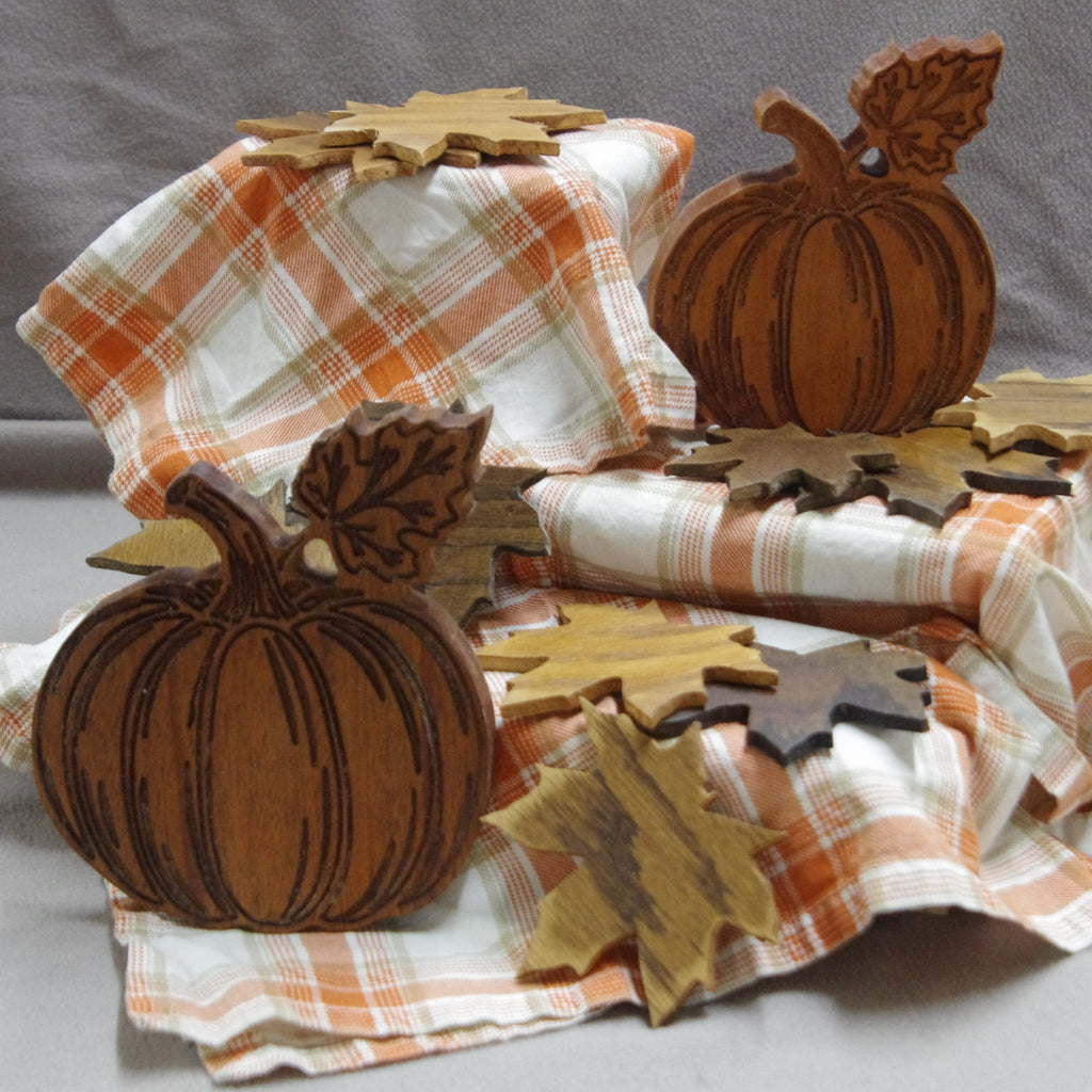 Decorative arrangement with pumpkins, leaves on orange plaid fabric