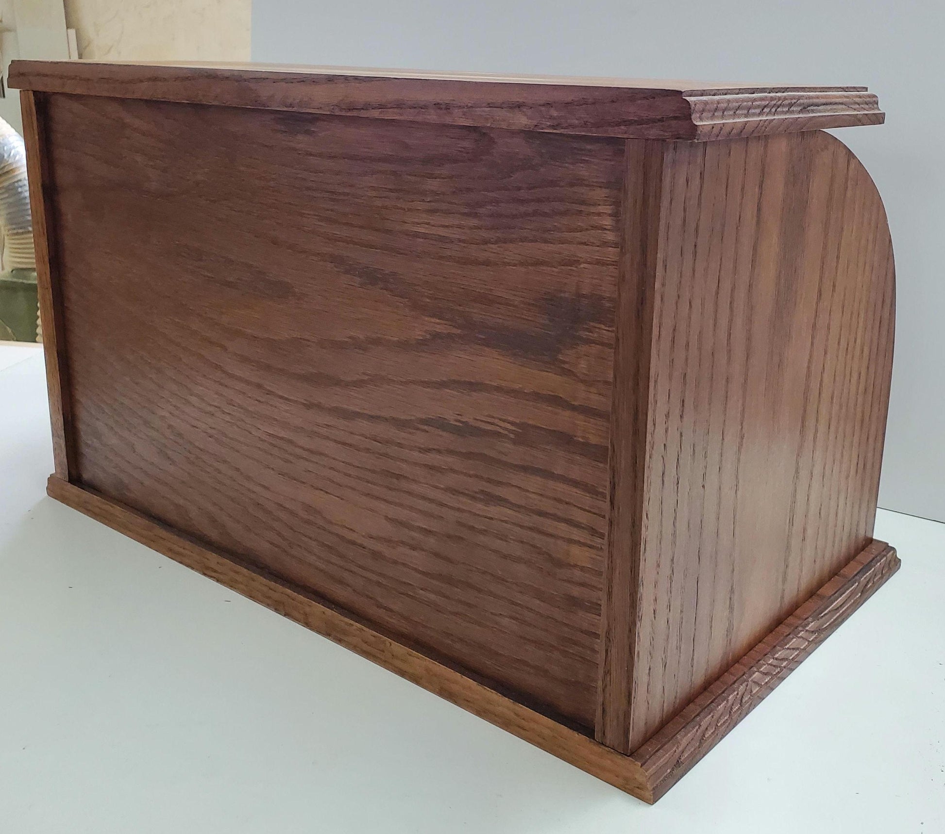 Back of Oak bread box with a roll-top door, crafted from natural oak wood that highlights the beautiful grain. The spacious interior helps keep bread and baked goods fresh, while the sturdy construction and classic design bring a warm, rustic touch to your kitchen. Stained with a medium reddish-brown stain for a rich, inviting look.