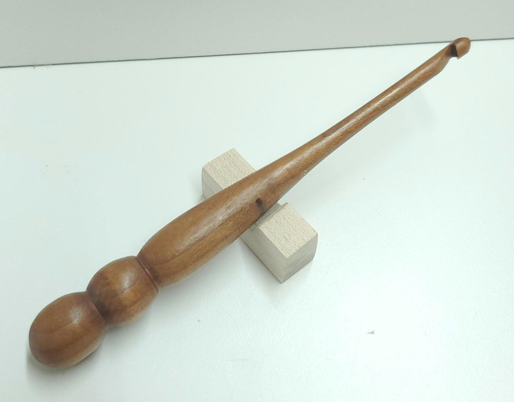 This 5mm crochet hook is expertly hand-turned from warm, reddish cherry wood, showcasing its natural luster and subtle grain variations. Each piece is carefully crafted to offer a smooth, ergonomic feel that enhances your crochet experience. While more hooks will be created from cherry, every hook is unique—boasting its own character and rich tone, perfect for adding a touch of handcrafted beauty to your toolkit.